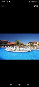 a picture of a swimming pool with white chairs at Búzios Beach Resort Residencial 1322 in Búzios