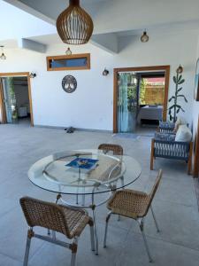 a glass table and chairs in a living room at Brisa Mar Suítes in Arraial d'Ajuda