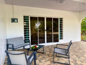 a patio with chairs and a table and windows at TIVINI Houses in Bora Bora