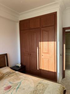 a bedroom with a bed and a large wooden closet at Vue sur mer in El Harhoura