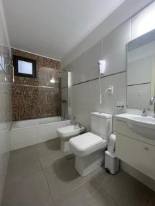 a bathroom with a toilet and a sink and a tub at Terra Malbec in Godoy Cruz +10 photos