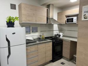 a kitchen with a white refrigerator and a stove at Terra Malbec in Godoy Cruz