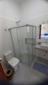 a bathroom with a shower and a toilet and a sink at Brisa Mar Suítes in Arraial d'Ajuda