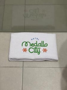 a white towel with the words melaleuca city on it at Hotel Medallo City in Medellín +27 photos
