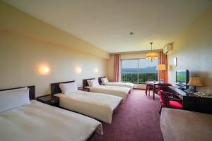 Postel nebo postele na pokoji v ubytování Tsumagoi Prince Hotel