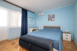 a blue bedroom with a bed and a chair at Seaside holiday house Zubovici, Pag - 22859 in Zubovići