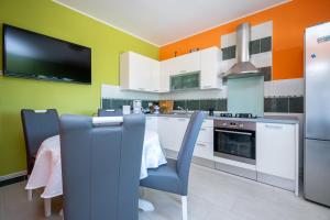a kitchen with a table and a tv on the wall at Seaside holiday house Zubovici, Pag - 22859 in Zubovići +18 photos