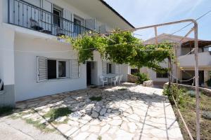 a white house with a patio in front of it at Seaside holiday house Zubovici, Pag - 22859 in Zubovići
