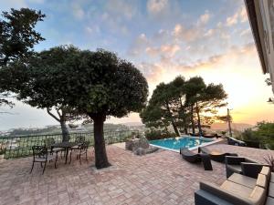 eine Terrasse mit einem Baum und einem Pool in der Unterkunft Family friendly house with a swimming pool Mundanije, Rab - 23393 in Rab + 16 Fotos