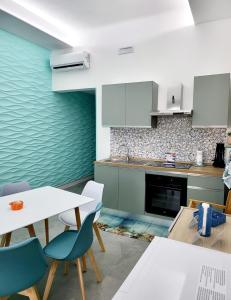a kitchen with a table and some chairs and a counter at Aquamarina Rooms in Porto Cesareo