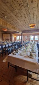 a long dining room with a long table and chairs at Skotten Seter - Bed & Husky in Mork