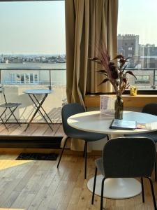 a table and chairs in a room with a balcony at Le Studio Grimaldi in Ostend