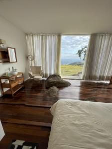 a bedroom with a bed and a large window at Cabana Pico do Gavião in Andradas