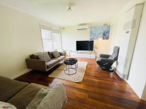 a living room with a couch and a tv at D118 Cawood Family Stay in Sunshine