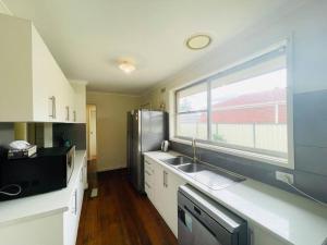 a kitchen with a sink and a large window at D118 Cawood Family Stay in Sunshine