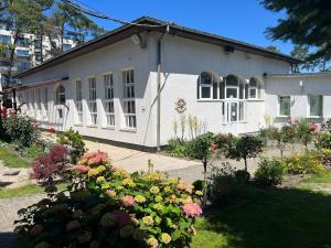 a white house with flowers in front of it at ORW Rzemieślnik in Międzywodzie