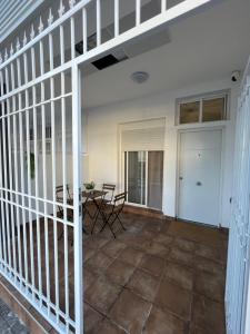 porche con mesa, sillas y valla en Apartamentos ESPIGAS PUERTO, en Valencia