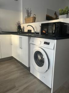 una cocina con lavadora y microondas en Apartamentos ESPIGAS PUERTO, en Valencia