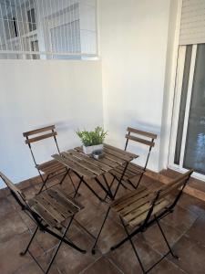Una mesa y sillas de madera con una planta en maceta. en Apartamentos ESPIGAS PUERTO, en Valencia 5 fotos más