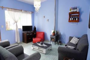 ein blaues Wohnzimmer mit zwei Sofas und einem roten Sessel in der Unterkunft El Arrayan " No acepta mascotas" in Tacuarembó