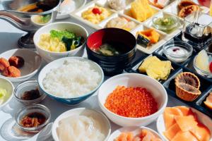 a table topped with bowls of different types of food at Hanabishi Hotel in Hakodate