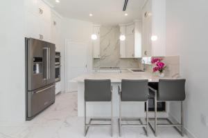 a kitchen with a refrigerator and a table with chairs at Luxurious 4 Bedroom Home on Seven Mile Corridor in the Heart of Cayman with a Private Pool in Seven Mile Beach