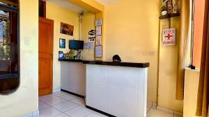 a kitchen with a counter and a tv on a wall at Hospedaje Sol de Oro in Nazca