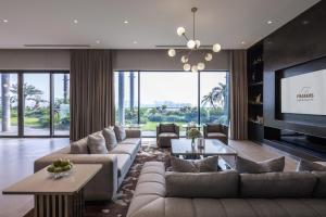 a living room with a couch and a tv at Fraser Residence Hanoi in Hanoi