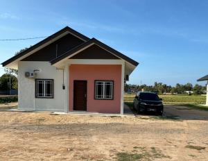 a house with a car parked in front of it at Afdal homestay in Pantai Cenang