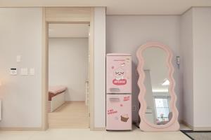 ein Zimmer mit einem Hello Kitty Kühlschrank neben einer Tür in der Unterkunft Pink room 4 bedroom in Seoul