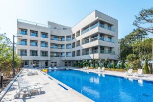 a hotel with a swimming pool in front of a building at Dongho Beach Hotel in Gochang 