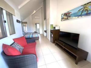 ein Wohnzimmer mit Couch und Flachbildfernseher in der Unterkunft Osprey Holiday Village Unit 203 1 Bedroom in Exmouth