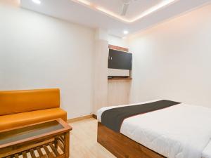 Un dormitorio con una cama y un televisor en una pared. en Hotel Millenium, en Lucknow 21 fotos más