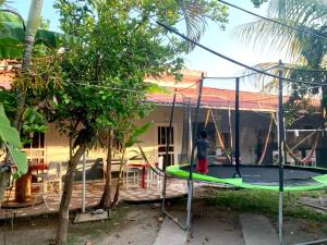 拉塞瓦Hotel&Hostal Trinidad的房屋前有蹦床的人