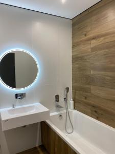 a bathroom with a sink and a mirror and a tub at Апартаменти в районі АВТОВОКЗАЛУ Поблизу Обласноі лікарні ЖК Great House,ЖК Арена in Rivne