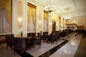 a restaurant with tables and chairs in a room at Ramada by Wyndham Plovdiv Trimontium in Plovdiv