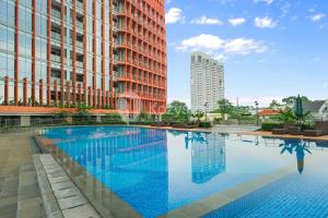 a large swimming pool in a city with buildings at Altin by Kozystay - TB Simatupang in Jakarta