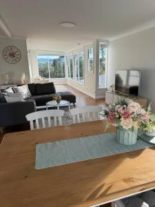 a living room with a table with flowers on it at Sunny Rose in Shellharbour +25 photos