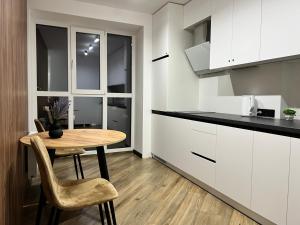 Una cocina con una mesa y sillas en una habitación. en Апартаменти в районі АВТОВОКЗАЛУ Поблизу Обласноі лікарні ЖК Great House,ЖК Арена, en Rivne