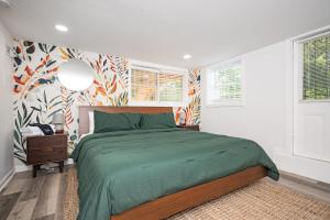 a bedroom with a bed with a green bedspread at Chic 2-Bed Haven with Vibrant Décor in SE Atlanta in Atlanta