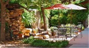 a patio with an umbrella and chairs and a stone wall at Hotel Garza in Post