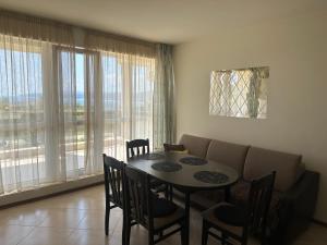 een eetkamer met een tafel, stoelen en een bank bij Apartament Savva in Byala
