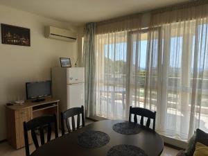 een eetkamer met een tafel en stoelen en een raam bij Apartament Savva in Byala