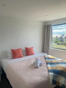 ein Schlafzimmer mit einem großen Bett mit Fenster in der Unterkunft Modern luxury four bedroom house in Christchurch