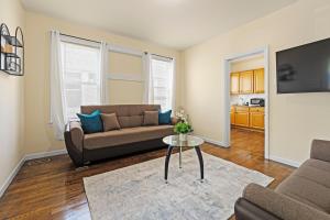 a living room with a couch and a table at The Commuter Dream Apartment close to NYC in Newark