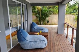 a porch with two blue chairs and a table at Ballito Home, Private Pool & Solar in Ballito