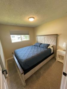 a bedroom with a bed with blue sheets and a window at Photo Op with Sasquatch 2 min to walk Silver Mtn in Kellogg +38 photos