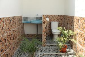 a bathroom with a toilet and a sink and plants at Melbao Homestay in Gili Islands