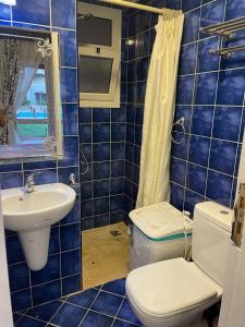 a blue tiled bathroom with a toilet and a sink at Porto Sharm elsheikh-Aqua park view in Sharm El Sheikh