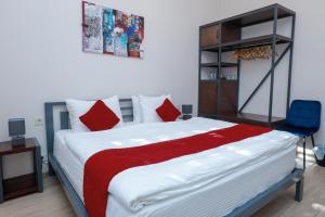 ein Schlafzimmer mit einem großen Bett und roten Kissen in der Unterkunft Syune Mini Hotel in Gjumri
